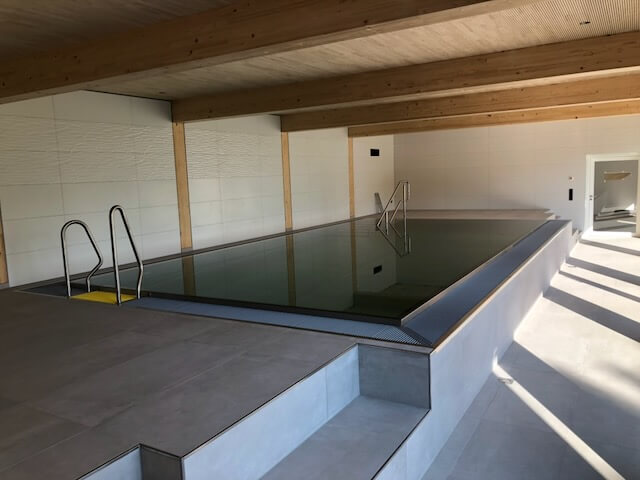 Edelstahl-Schwimmbecken mit Treppenanlage in einem Hallenbad
